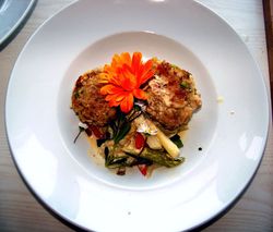 Teller mit Spargeln, zwei Semmelknödeln und einer orngefarbenen Blüte