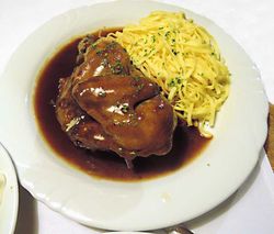 Teller mit coq au vin und Tagliatelle