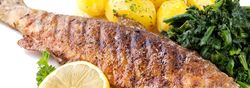 Ganzer gebratener Fisch mit Kartoffeln und Spinat