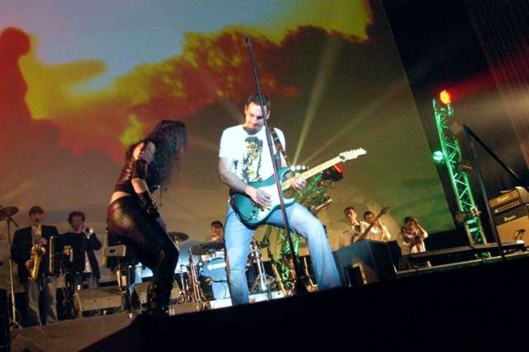Julia Neigel mit Gitarrist und Band auf einer Bühne