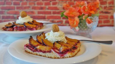 Zwei Teller mit Zwetschgenkuchen und Sahne