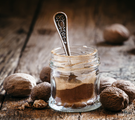 Muskatnüsse und Gläschen mit Muskatnusspulver