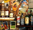 Holzwand mit Postkarten und sehr vielen Whiskyflaschen