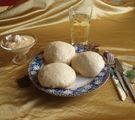 Gedeck mit Dampfnudeln, einer Schüssel mit Weinsoße und ein Glas Wein