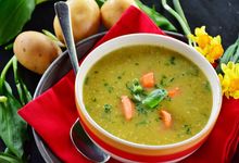 Schüssel mit Löffel und Kartoffelsuppe