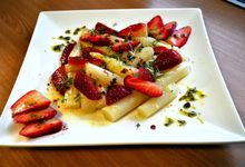 Weißer, viereckiger Teller mit Spargeln und Erdbeeren