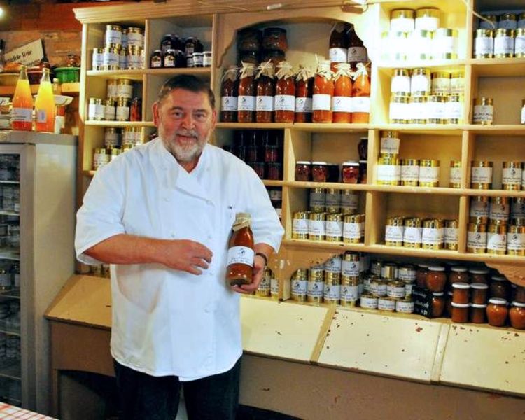 Franz Klöfer vor Regalen mit Dosen und Marmeladengläsern