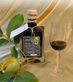 Flasche und Schnapsglas mit Walnusslikör und einem grünen Zweig mit einer Walnuss