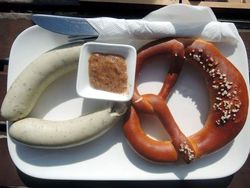 Teller mit Weißwurst und Brezel