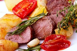 Lammfilets, Kartoffeln, Kräuter und zwei halbe Tomaten