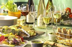 Gedeckter Tisch mit Wein, Fisch und anderen Beilagen