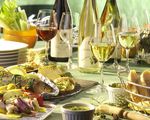 Gedeckter Tisch mit Wein, Fisch und anderen Beilagen