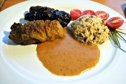 Teller mit Wirsingröllchen, Sauce, Reis und aufgeschnittene Tomaten