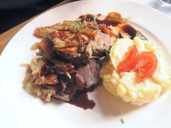Teller mit Braten und Beilagen