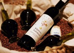 Flasche und Gefäße mit Traubenkernöl in einem Sack mit Traubenkernen