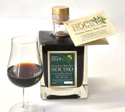 Flasche und Glas mit Walnusslikör (Nocino)